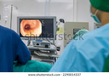 A doctor or surgeon in a light blue protective gown did a colonoscopy or gastroscopy inside operating theatre in the hospital.EGD technology for cancer screening.Blur green background and foreground. Royalty-Free Stock Photo #2290014337