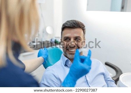 A young female dentist showing invisalign to patient in dental clinic, teeth check-up and Healthy teeth concept Royalty-Free Stock Photo #2290027387