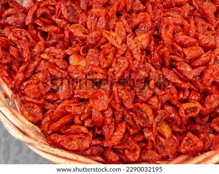Close-up of part of an open basket full of healthy, shiny bright red sun-dried tomatoes in a market on the Italian island of Sicily. High quality photo