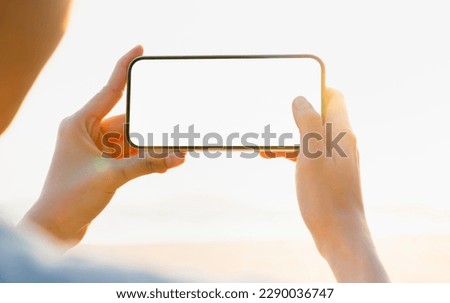Young woman hand holding smartphone with taking photo on beach, Take your screen to put on advertising. Summer vacation concept.