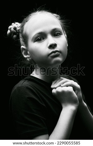Black-and-white portrait of a beautiful girl who looks calmly and thoughtfully at the camera. Psychological picture. Children, emotions.