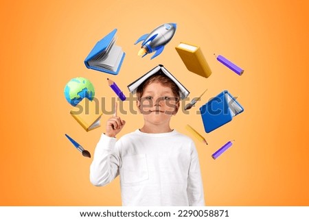 Portrait of smiling little boy standing with book on head and pointing upwards over orange background with school icons around him. Concept of education