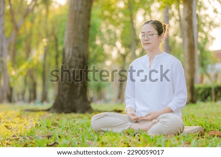 A woman do meditation in a peaceful  garden in Thai temple. Royalty-Free Stock Photo #2290059017