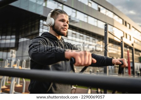 Adult caucasian man training outdoor in the city day Male athlete using rubber elastic resistance band tubes in his daily workout routine Real people health and fitness concept copy space