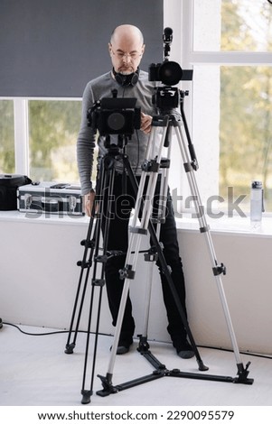 Videographer uses two cameras in parallel to shoot a clip in the studio. News