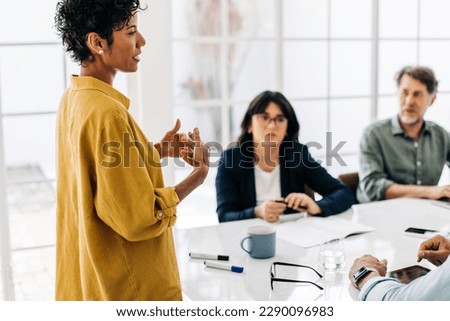 Female team leader giving a speech in a boardroom. Black business woman discussing a project with her colleagues in an office. Group of business professionals having a meeting. Royalty-Free Stock Photo #2290096983