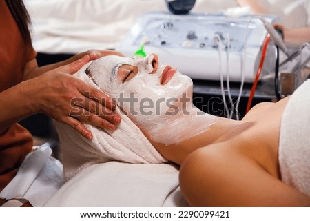 caucasian white woman having face treatment in spa salon on the bed, beauty facial mask