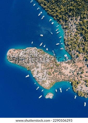 Aerial drone photo of Binlik Bay, located in the midst of Göcek and Dalaman, Fethiye. Daily tour boats and private yachts anchor to have serenity and enjoy the secluded bay. Royalty-Free Stock Photo #2290106293