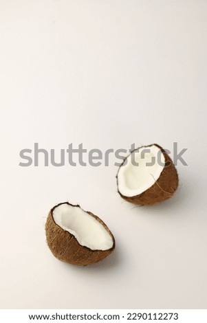 exotic fruit of the coconut tree brown coconut with fibers and snow-white flesh on a light white background and green mint leaves. for advertising banners, labels, menu splash screens, and more