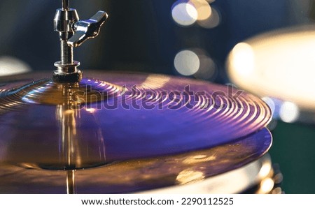 Drum cymbal close-up on a dark blurred background.
