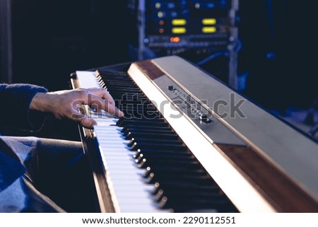 A man plays the electronic piano, hands close-up.