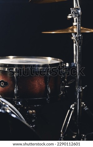 Snare drum on a blurred dark background, part of a drum kit.
