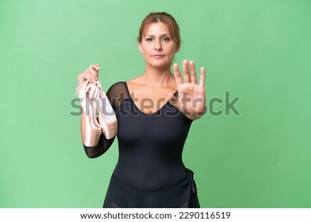 Middle-aged caucasian woman practicing ballet over isolated background making stop gesture