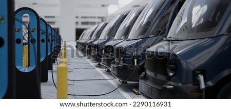 CU shot of fleet modern electric EV delivery vans are being charged in company parking garage Royalty-Free Stock Photo #2290116931