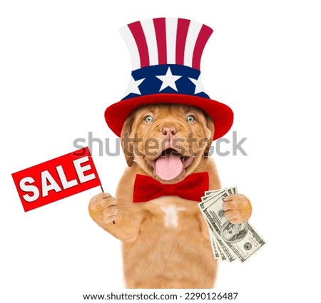 Happy Mastiff puppy wearing like Uncle Sam holds dollars USA and shows signboard with labeled "sale". isolated on white background