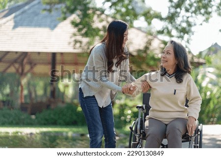 Nursing home, Young caregiver helping senior woman in wheelchair, Volunteer.