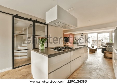 a modern kitchen with wood flooring and white cabinetd appliances on the counters in the center of the room