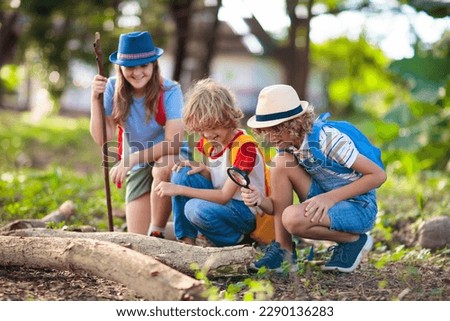 Kids explore nature. Children hike in sunny summer park. Scout club and science outdoor class. Boy and girl watch plants through magnifying glass. Kid exploring environment. Young explorer adventure. Royalty-Free Stock Photo #2290136283