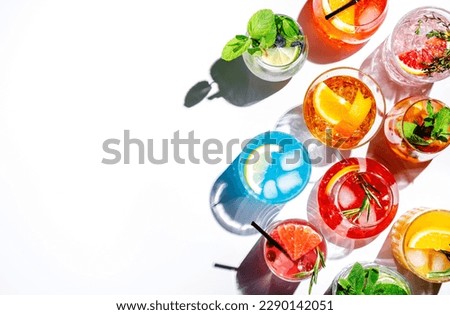 Summer cocktails drinks set. Assortment of multicolored strong and low alcoholic beverages for cocktail party. White background, hard light, shadows pattern, top view Royalty-Free Stock Photo #2290142051
