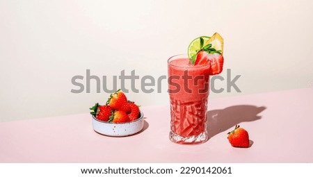Pelican summer non-alcoholic cocktail or mocktail drink with strawberry, banana, syrup, peach juice, lemon and ice in highball glass. Beige pink vanilla background, hard light, shadow pattern Royalty-Free Stock Photo #2290142061
