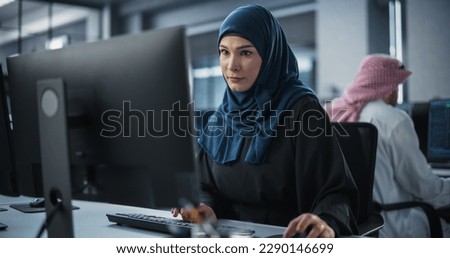 Young Arab Female Artificial Intelligence Engineer Working on Computer in a Technological Office. Young Middle Eastern Specialist Writing Software Code for an Innovative Big Data Blockchain Project