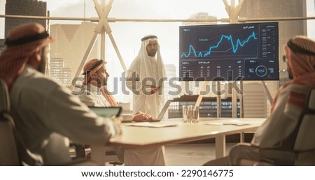 CEO Businessman Shows Data to a Group of Saudi Investors. TV Screen Shows Graphs, Product Sales Numbers, Revenue Growth Strategy, e-Commerce Analysis. Business Meeting Presentation in Conference Room Royalty-Free Stock Photo #2290146775