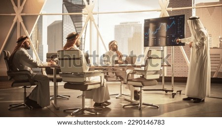 Saudi Operations Manager Delivering a Successful Presentation About a Lucrative Business Merger with International Partner. Board of Directors Cheering in Conference Room with a Million Dollar View Royalty-Free Stock Photo #2290146783