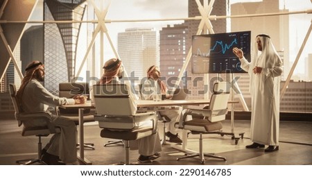 Saudi Operations Manager Delivering a Successful Presentation About a Lucrative Business Merger with International Partner. Board of Directors Cheering in Conference Room with a Million Dollar View Royalty-Free Stock Photo #2290146785