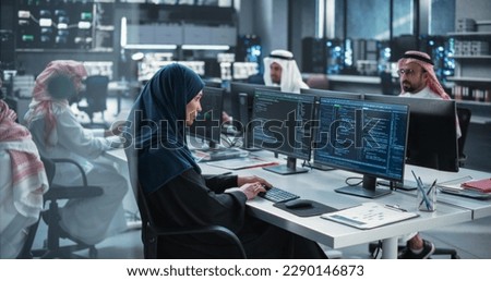Group of Multicultural Middle Eastern Men and Women Working in Research Center, Collaborating and Discussing a Project, Using Computers to Write Software Code, Develop Artificial Intelligence Service Royalty-Free Stock Photo #2290146873