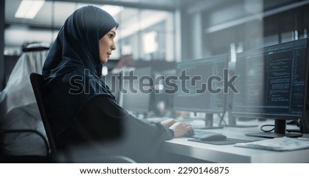 Portrait of a Thoughtful Middle Eastern Female Working on Computer in a Technological Corporate Office. Young Woman Writing Software Code for an Innovative Internet and Software as a Service Project