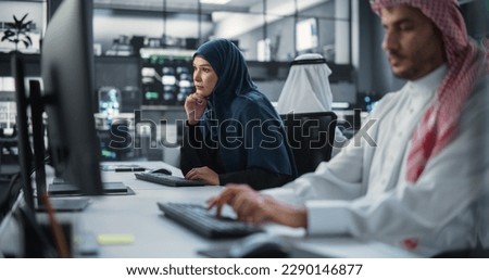 Portrait of a Thoughtful Middle Eastern Female Working on Computer in a Technological Corporate Office. Young Woman Writing Software Code for an Innovative Internet and Software as a Service Project