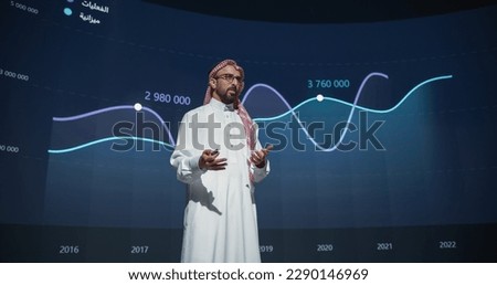 Successful Middle Eastern Speaker Presenting a New Product, Showing Infographics, Statistics Animation on Big Screen. Talking About Business Performance at a Press Conference Royalty-Free Stock Photo #2290146969