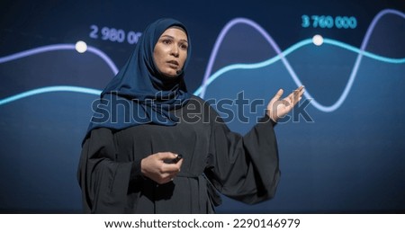 Business Expo Stage: Famous Inspirational Speaker From Gulf Region Talking about Technology, Science, Success, Productivity. Tech Industry Businesswoman in Traditional Arab Hijab Giving a Presentation Royalty-Free Stock Photo #2290146979