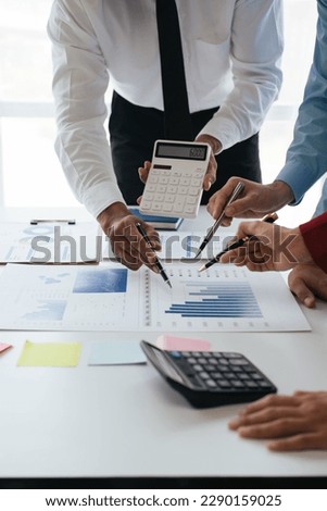 Close up of businesspeople are using calculator for analyze the statistics of investment online working data.