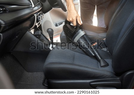 Employee cleaning car with portable vacuum cleaner Royalty-Free Stock Photo #2290161025