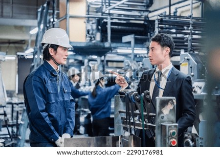 Management giving a warning to factory workers Royalty-Free Stock Photo #2290176981