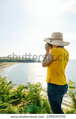 Blonde Tourist Capturing Coastal Beauty: Casual, Colorful, and Vibrant with Midday Light