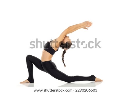Yoga, sport, training and lifestyle concept - Young woman doing yoga exercise. Portrait of young beautiful woman in black sportswear doing yoga practice.