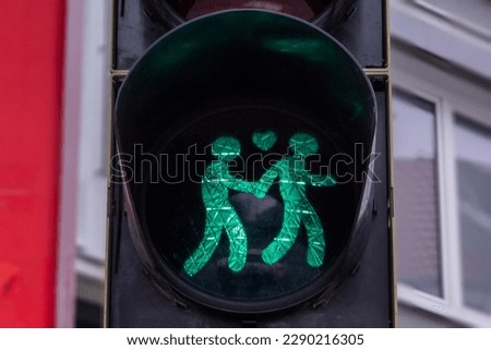 A pedestrian traffic light in support of gay female lesbian couple in Germany. Traffic light showing two women crossing holding their hands. Gay friendly concept.