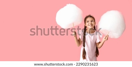 Cute little girl with cotton candy on pink background with space for text Royalty-Free Stock Photo #2290231623