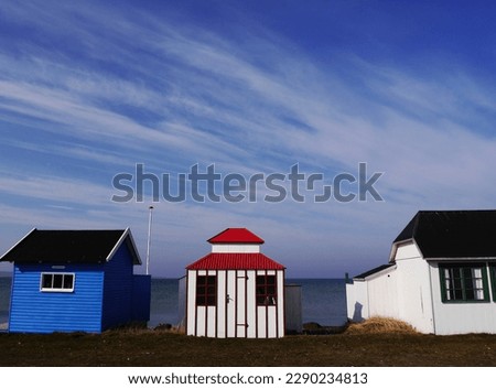 Row of colourful beach huts against blue sky on Danish island of Aeroe. High quality photo Royalty-Free Stock Photo #2290234813