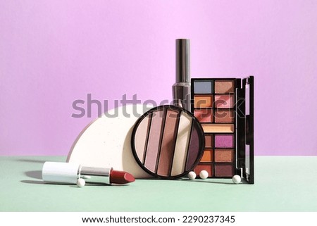 Decorative cosmetics with podium on table near lilac wall Royalty-Free Stock Photo #2290237345