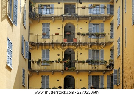 Typical yellow building of old Milan - houses with balcony and doors facing onto the landing - vintage house from the 50s and 60s - Milan fashion week and capital of design - real estate picture 