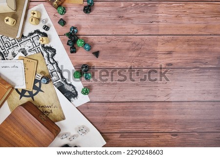 Tabletop role playing flat lay background with colorful RPG dices, rule books and notes on wooden background with copy space