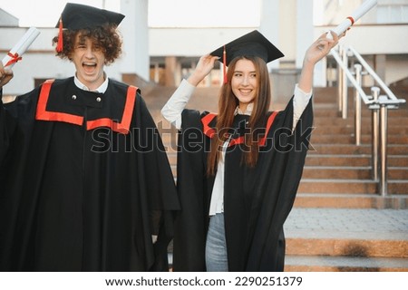 Portrait of two happy graduating students