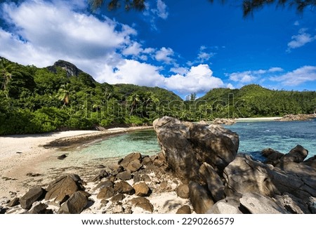 Port glaud beach, Beach, rock boulders and mountain, Mahe Seychelles