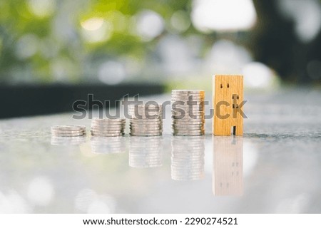 Wood house and row of coin money on wood table and , selective focus, Planning to buy property. Choose what's the best. A symbol for construction ,ecology, loan concepts	