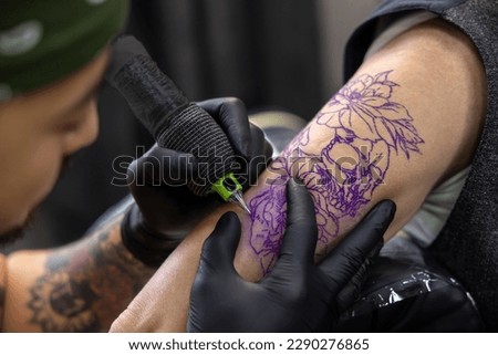 Male tattoo master working in the salon with a customer Royalty-Free Stock Photo #2290276865