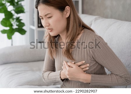asian woman have chest pain caused by heart disease, leak, dilatation, enlarged coronary heart, press on the chest with a painful expression Royalty-Free Stock Photo #2290282907