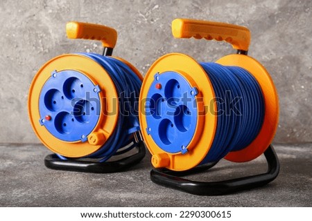 Extension electric cable reels on grunge background